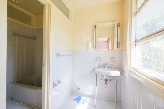 1614 N Patterson St, Valdosta, GA 31602 - bathroom featuring a sink, tile walls, bathtub / shower combination, and a wainscoted wall