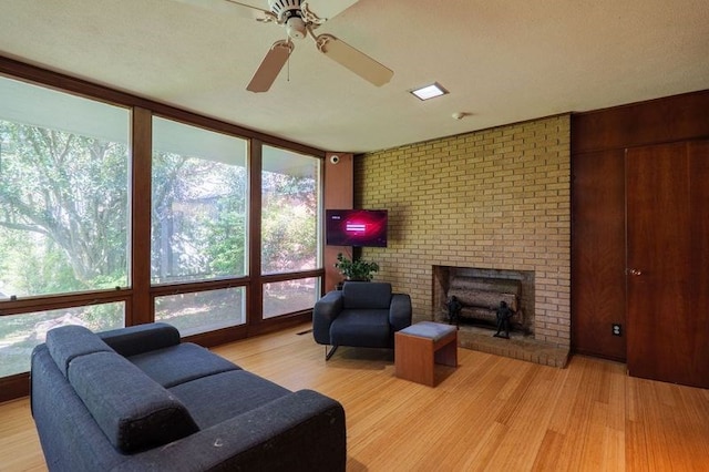 1614 N Patterson St, Valdosta, GA 31602 - living area featuring brick wall, light wood finished floors, ceiling fan, and a brick fireplace
