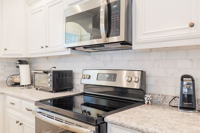 4137 Nelson Hill Pl, Hahira, GA 31632 - kitchen with appliances with stainless steel finishes, tasteful backsplash, white cabinets, and light stone counters