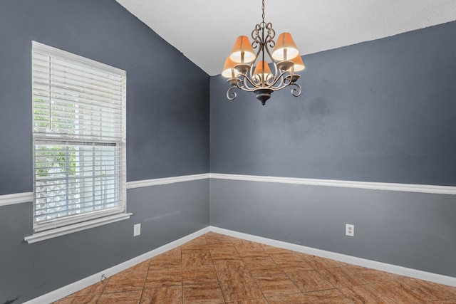 unfurnished room with lofted ceiling, baseboards, and a notable chandelier