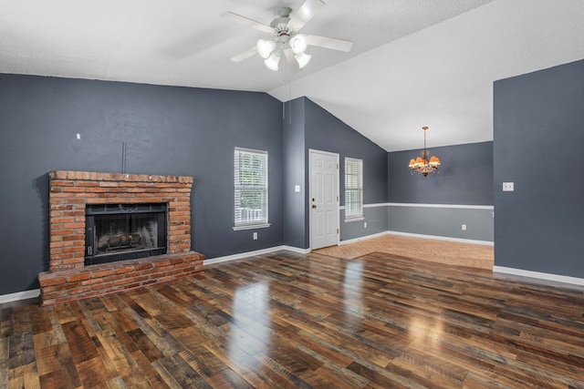 unfurnished living room with baseboards, lofted ceiling, ceiling fan with notable chandelier, a fireplace, and wood-type flooring