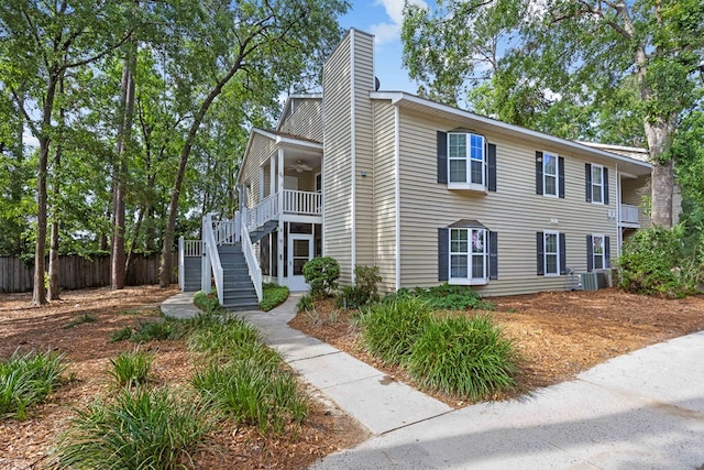 townhome / multi-family property with stairway, a ceiling fan, a chimney, fence, and cooling unit