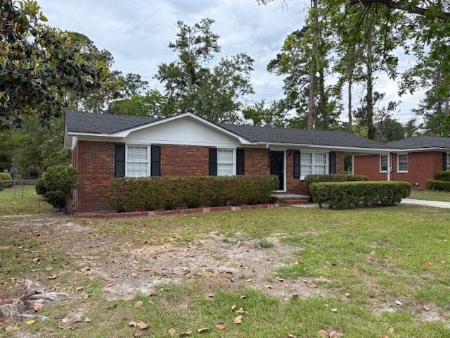 ranch-style home featuring brick siding and a front yard