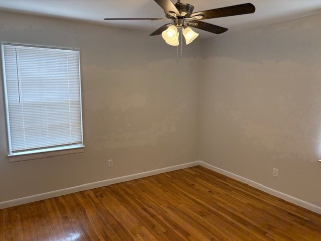 empty room with baseboards, ceiling fan, and wood finished floors