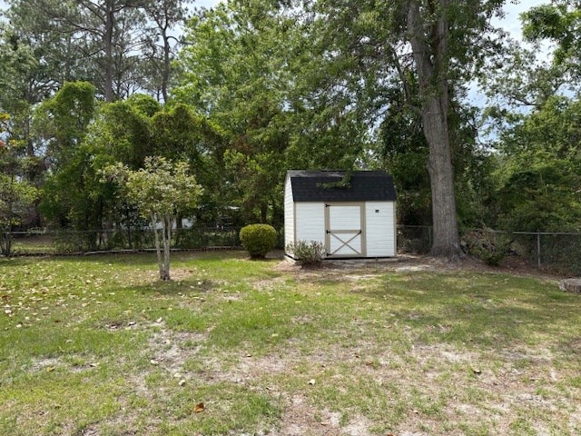view of yard featuring an outbuilding, a shed, and a fenced backyard