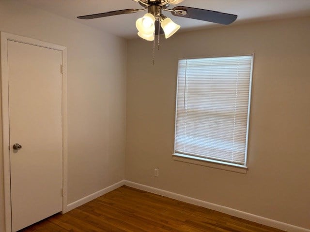 unfurnished room featuring a ceiling fan, baseboards, and wood finished floors