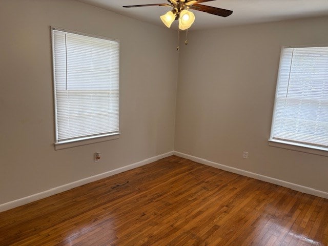 empty room featuring a ceiling fan, baseboards, and wood finished floors