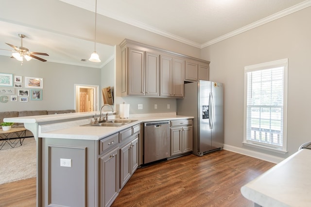 kitchen featuring sink, stainless steel appliances, dark wood-type flooring, kitchen peninsula, and pendant lighting