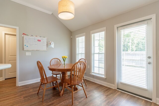 dining space with dark hardwood / wood-style flooring, vaulted ceiling, and a healthy amount of sunlight