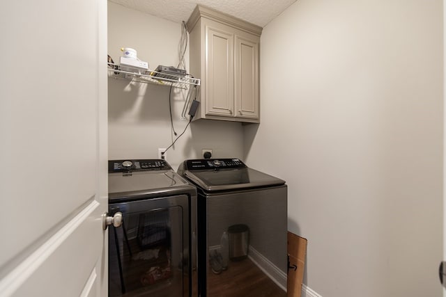 clothes washing area featuring washer and clothes dryer, dark hardwood / wood-style flooring, cabinets, and a textured ceiling