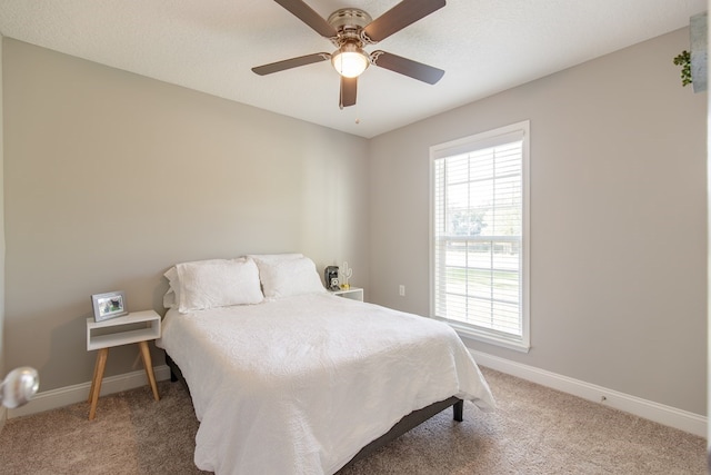 bedroom featuring ceiling fan, carpet floors, and a textured ceiling