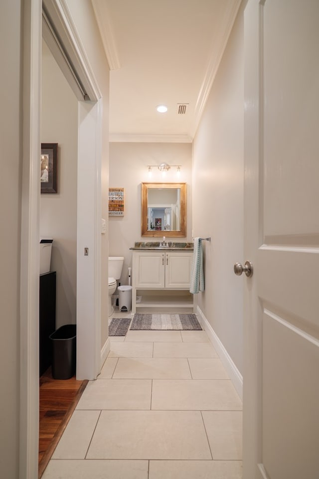 bathroom with toilet, hardwood / wood-style floors, vanity, and ornamental molding