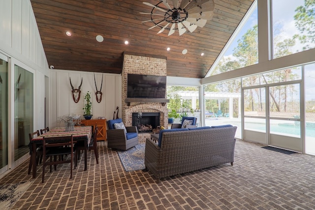 sunroom / solarium with a fireplace, ceiling fan, lofted ceiling, and wood ceiling