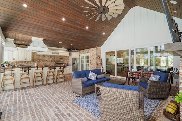 view of patio with exterior bar, an outdoor hangout area, area for grilling, and ceiling fan