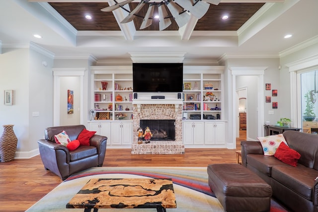 living room featuring light hardwood / wood-style floors, a brick fireplace, ceiling fan, and crown molding