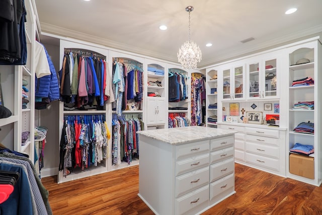 walk in closet with a chandelier and wood-type flooring