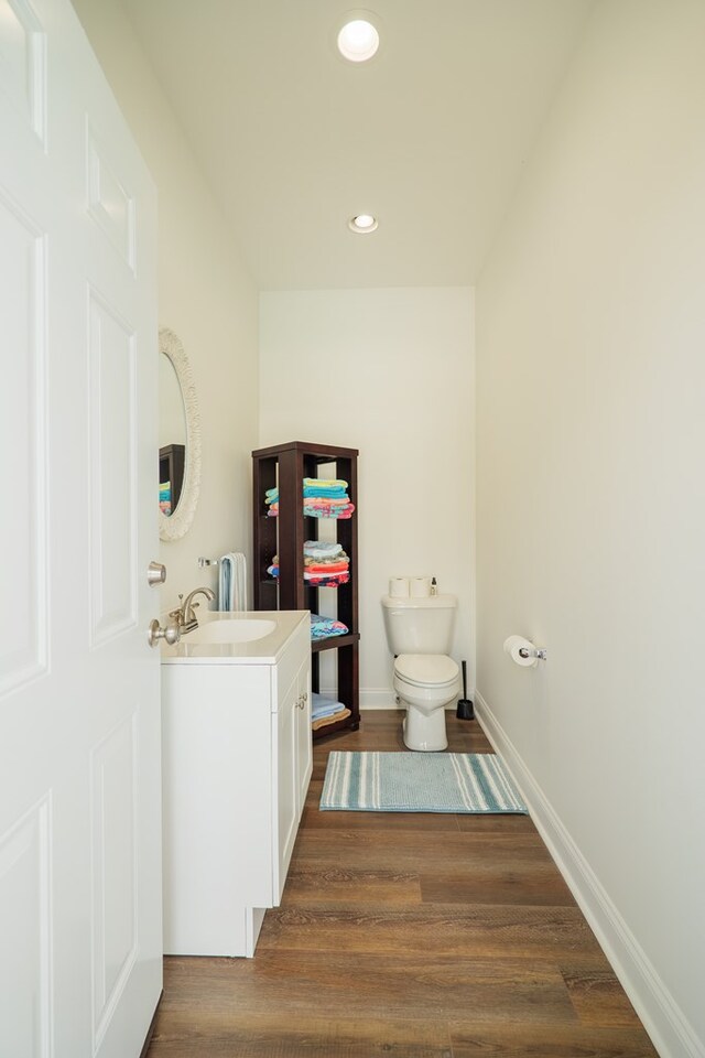 bathroom featuring wood-type flooring, vanity, and toilet