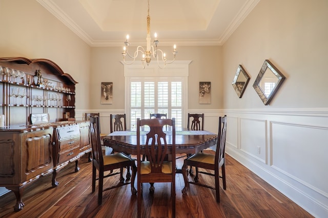 dining area with a raised ceiling, crown molding, dark hardwood / wood-style flooring, and a notable chandelier