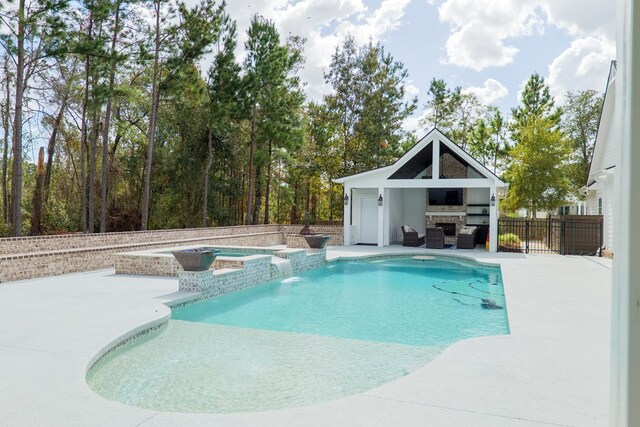 view of pool with pool water feature, an outbuilding, a patio, and an in ground hot tub