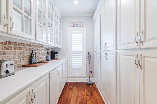 bar with light stone countertops, dark hardwood / wood-style flooring, backsplash, crown molding, and white cabinetry