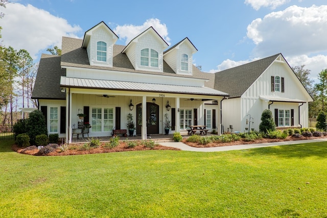 view of front of home with ceiling fan, covered porch, and a front yard