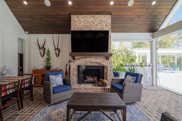 sunroom / solarium featuring lofted ceiling, an outdoor brick fireplace, and wooden ceiling