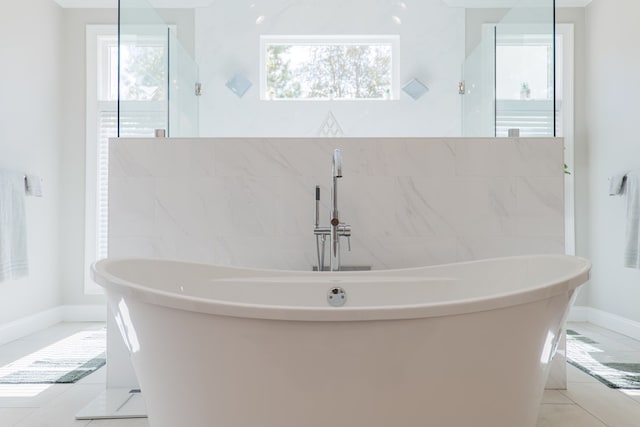 bathroom with a bath and tile patterned floors