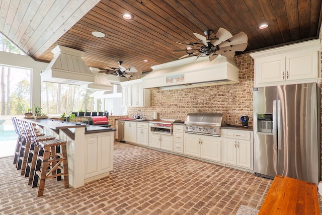 kitchen featuring kitchen peninsula, stainless steel fridge with ice dispenser, ventilation hood, and wood ceiling