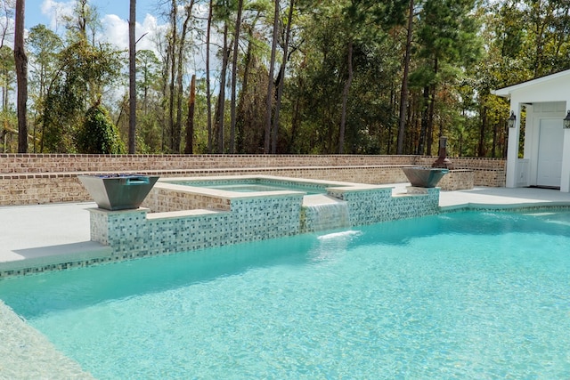 view of pool with pool water feature and an in ground hot tub