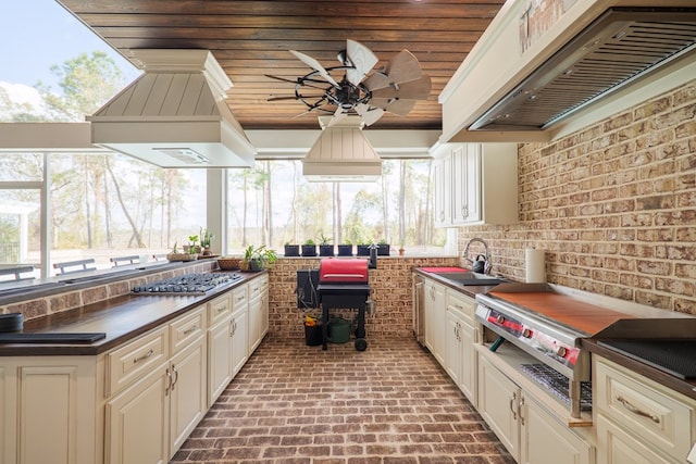 kitchen with cream cabinetry, premium range hood, and a wealth of natural light