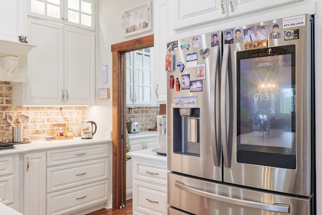 kitchen featuring hardwood / wood-style flooring, decorative backsplash, white cabinetry, and stainless steel refrigerator with ice dispenser