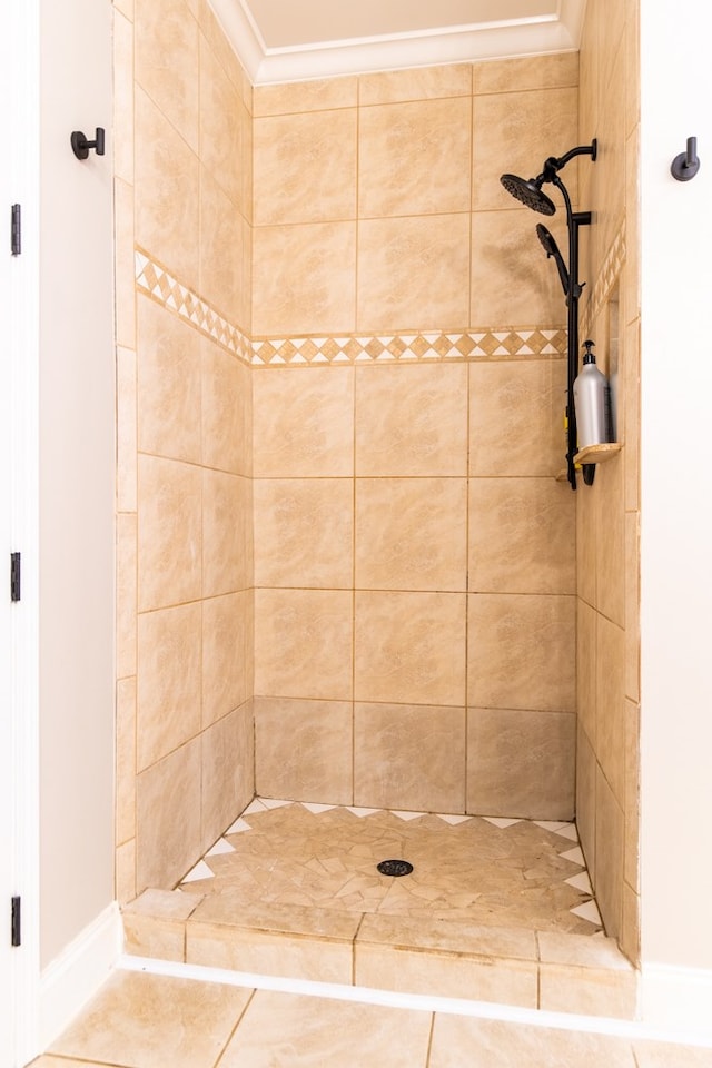 bathroom featuring crown molding, tile patterned flooring, and tiled shower