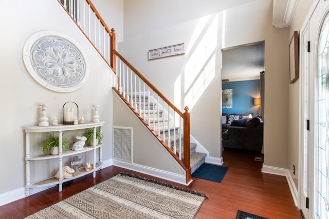 stairway with crown molding and wood-type flooring