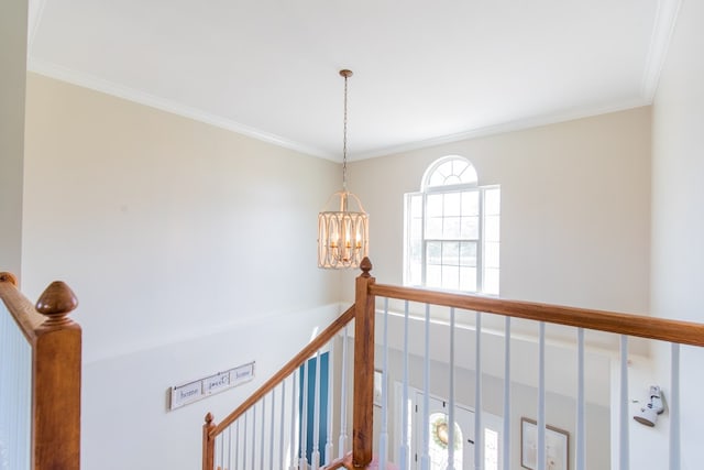 hall with ornamental molding and a notable chandelier