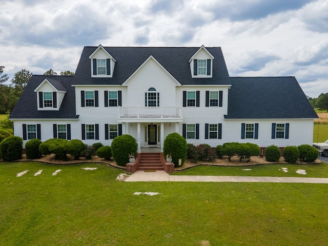 view of front of property with a balcony and a front lawn