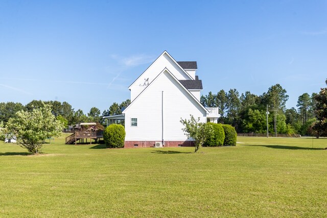 view of side of property with a deck and a lawn