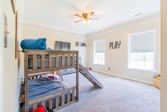 carpeted bedroom with ceiling fan and ornamental molding