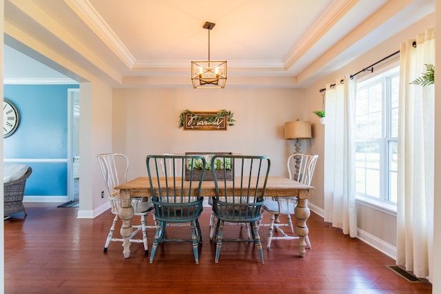 dining area with dark hardwood / wood-style flooring, a tray ceiling, and crown molding