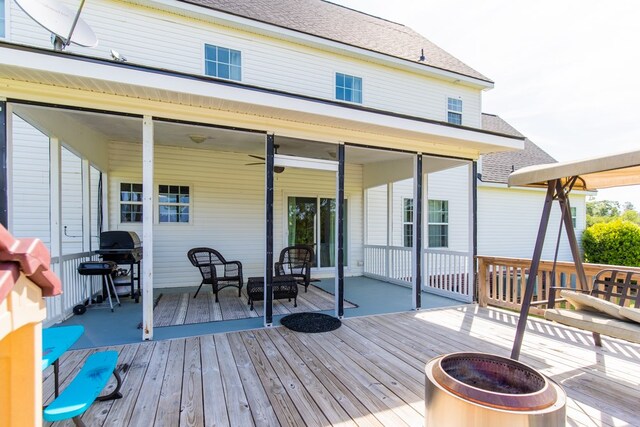 wooden deck with a fire pit and a grill