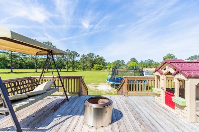 wooden terrace with a yard and a trampoline