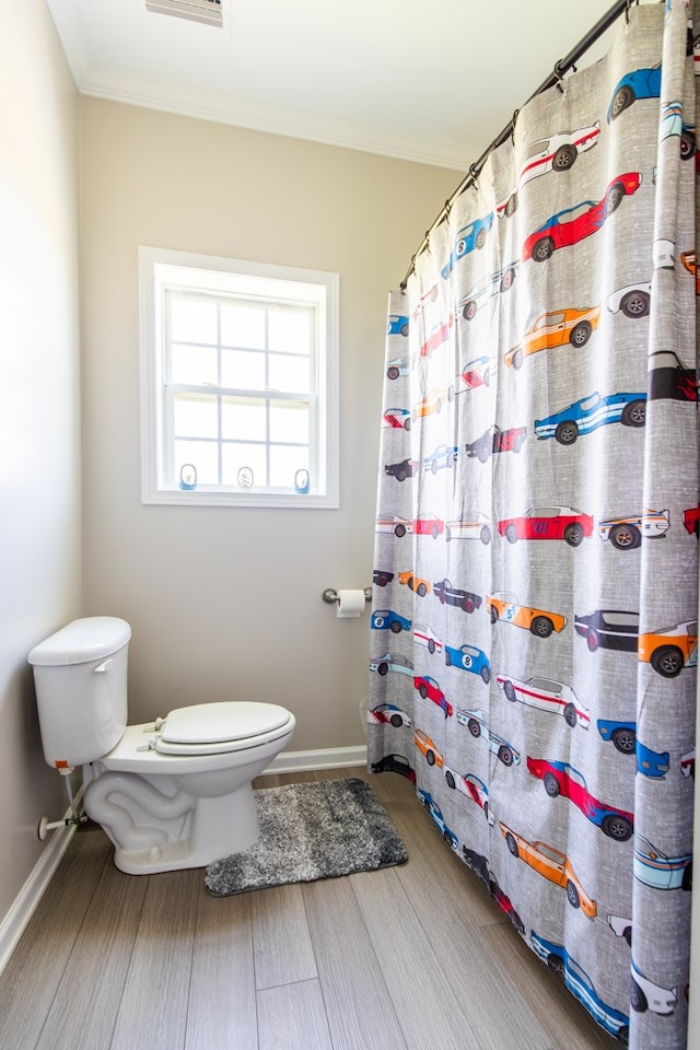 bathroom featuring walk in shower, ornamental molding, wood-type flooring, and toilet