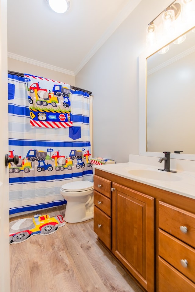 bathroom featuring walk in shower, hardwood / wood-style floors, toilet, vanity, and ornamental molding