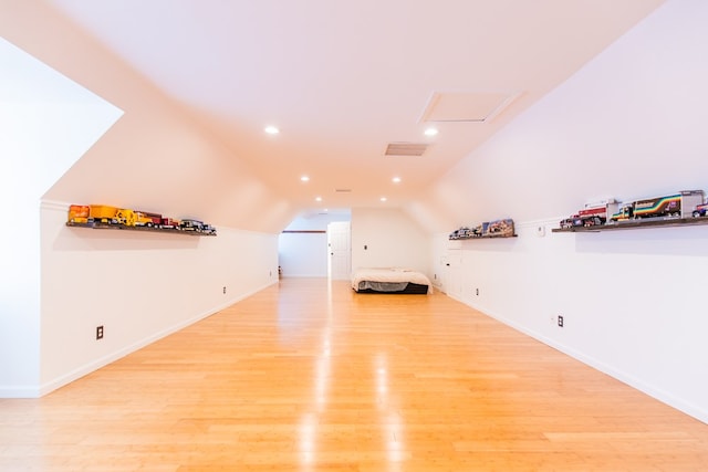 additional living space with light hardwood / wood-style flooring and vaulted ceiling