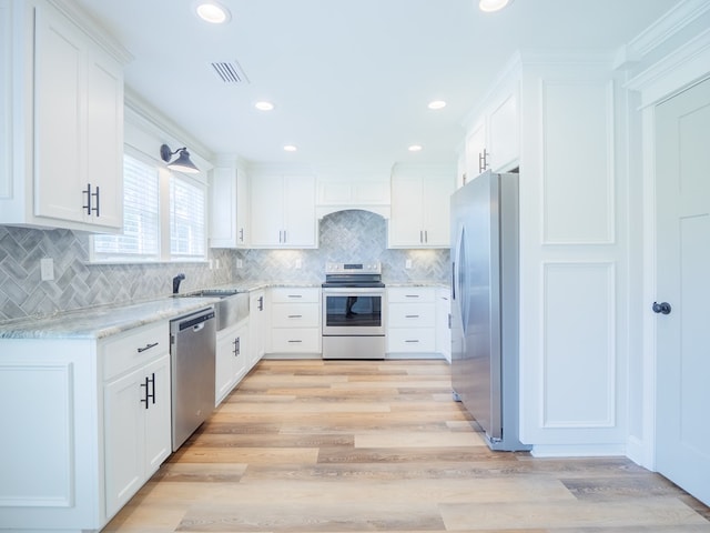 5674 Clydetta Dr, Lake Park, GA 31636 - kitchen featuring stainless steel appliances, a sink, white cabinets, light wood-style floors, and recessed lighting