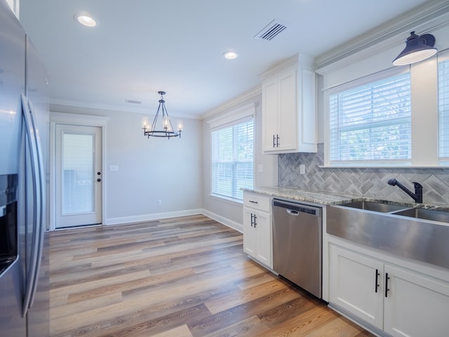 5674 Clydetta Dr, Lake Park, GA 31636 - kitchen featuring stainless steel appliances, a sink, a chandelier, white cabinetry, and backsplash