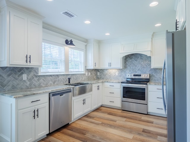 5674 Clydetta Dr, Lake Park, GA 31636 - kitchen featuring stainless steel appliances, a sink, white cabinetry, tasteful backsplash, and light wood-style floors