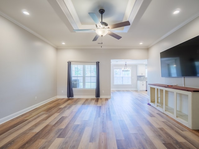 5674 Clydetta Dr, Lake Park, GA 31636 - unfurnished living room featuring crown molding, ceiling fan, light wood-style flooring, a chandelier, and a tray ceiling