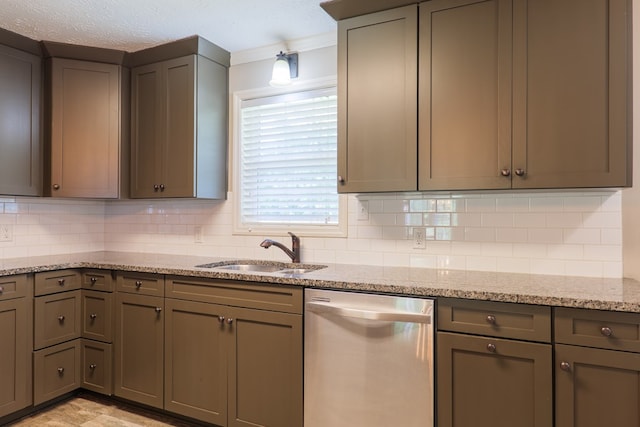 kitchen with dishwasher, decorative backsplash, light stone countertops, and sink