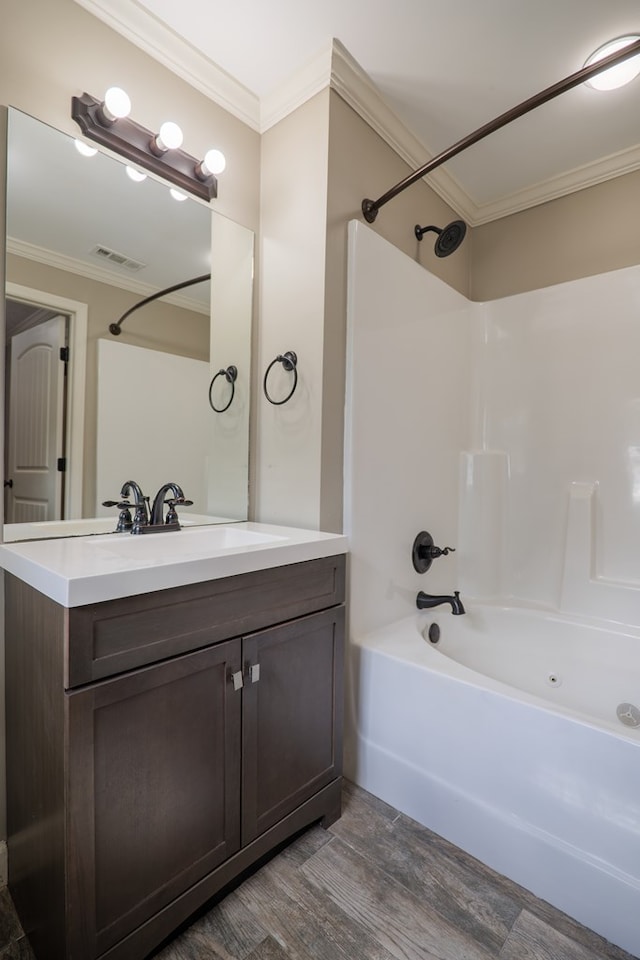 bathroom featuring hardwood / wood-style floors, vanity, crown molding, and shower / washtub combination