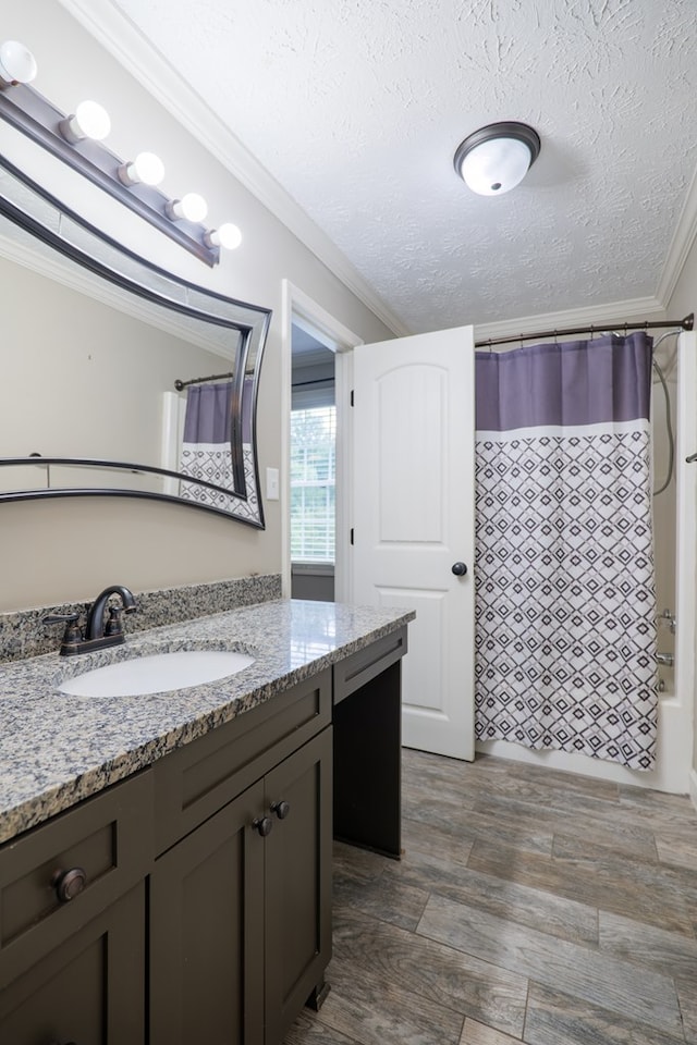 bathroom featuring vanity, shower / bath combination with curtain, crown molding, a textured ceiling, and wood-type flooring